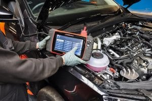 image of a mechanic showing a scanner with data displayed from the car