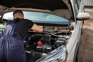 image of a mechanic working on a car engine
