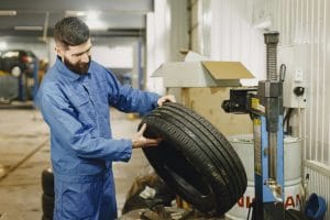 image of a mechanic inspecting a car tire
