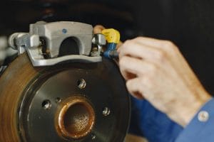 Image showing mechanic inspecting breaks on a car